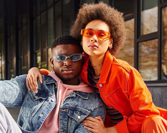 Casal sorrindo com roupas coloridas, imagem ilustrativa da agência de marketing digital DNA